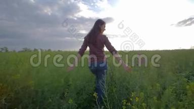 少女漫步绿油油的油菜花田，在天空的背景下欣赏大自然的美景